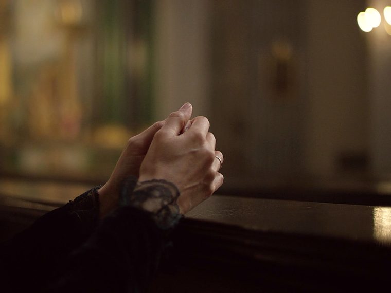Hands clasped together in a quiet moment of comfort